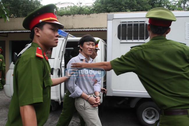Nhà báo Hoàng Khương tươi cười với đồng nghiệp trước khi lên xe bịt bùng về trại tạm giam (Ảnh: Nghĩa Phạm/Giaoduc.net.vn)